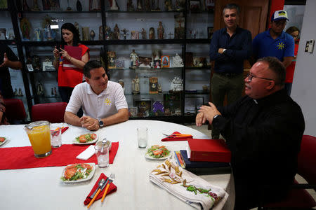 Presidential candidate Fabricio Alvarado Munoz of the National Restoration Party (PRN) and Father Sergio Valverde meet prior to a lunch in a Catholic charity in San Jose, Costa Rica March 31, 2018. REUTERS/Jose Cabezas