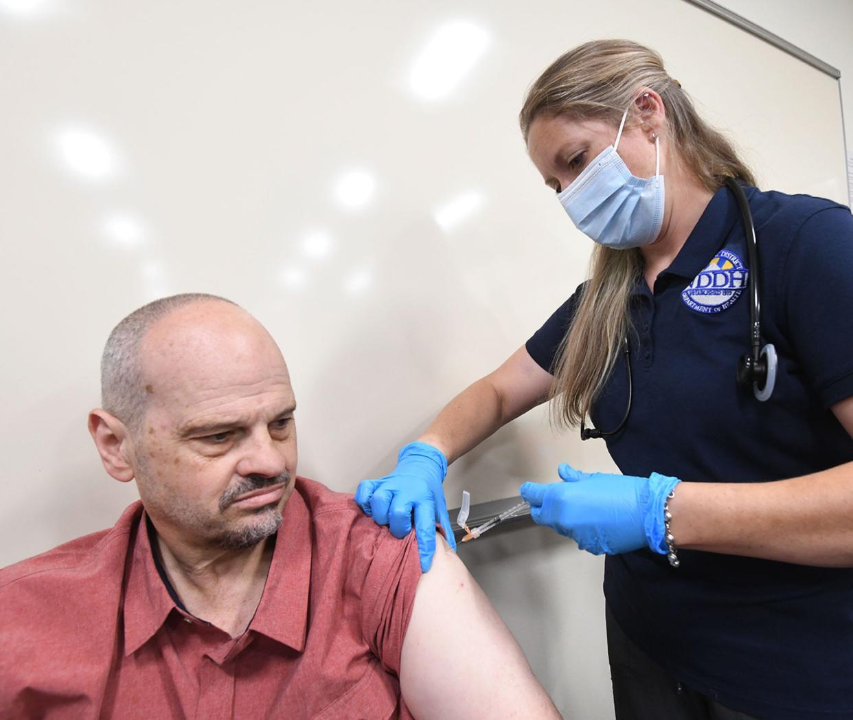 Marine veteran Neil Stanley of Dayville gets his second booster COVID-19 vaccination from public health nurse Janine Vose recently at Quinebaug Valley Community College in Dayville, Connecticut.