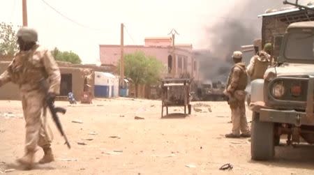 A still image taken from a video shows soldiers standing guard as smoke rises in the distance after a car bomb attack in Gao, northern Mali July 1, 2018. REUTERS/via Reuters TV
