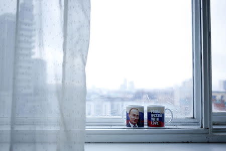 Mugs with a picture of Russian President Vladimir Putin are seen in this photo illustration taken in a hotel room in Kazan, Russia, July 31, 2015. REUTERS/Stefan Wermuth