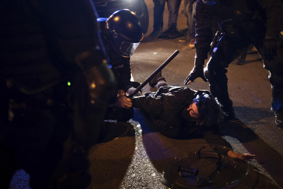 A demonstrator is detained by police during clashes following a protest condemning the arrest of rap singer Pablo Hasél in Barcelona, Spain, Saturday, Feb. 27, 2021. After a few days of calm, protests have again turned violent in Barcelona as supporters for a jailed Spanish rapper went back to the streets. (AP Photo/Felipe Dana)