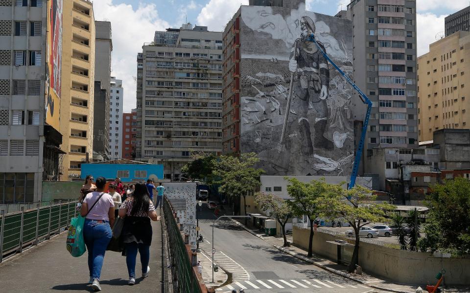 <p>El mural, titulado ‘El bombero forestal’, tiene 780 metros cuadrados y presenta a una figura heroica indefensa frente al poder destructor del fuego que arrasa la selva y mata a los animales. (Foto: Miguel Schincariol / AFP / Getty Images).</p> 