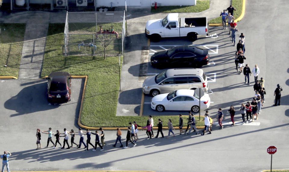 Estudiantes siendo evacuados después del tiroteo. (Mike Stocker/South Florida Sun-Sentinel via AP)