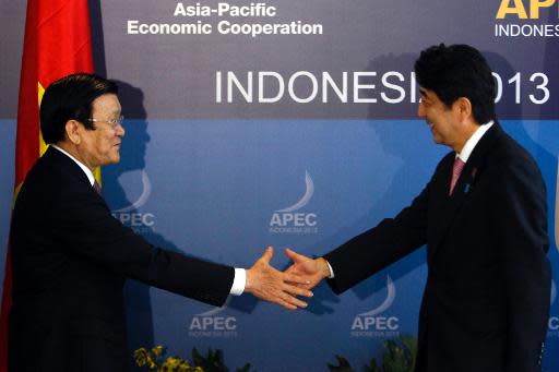 Vietnam's President Truong Tan Sang (L) shakes hands with Japan's Prime Minister Shinzo Abe during their bilateral meeting on the sidelines of the APEC Summit in Nusa Dua, Bali, on October 7, 2013