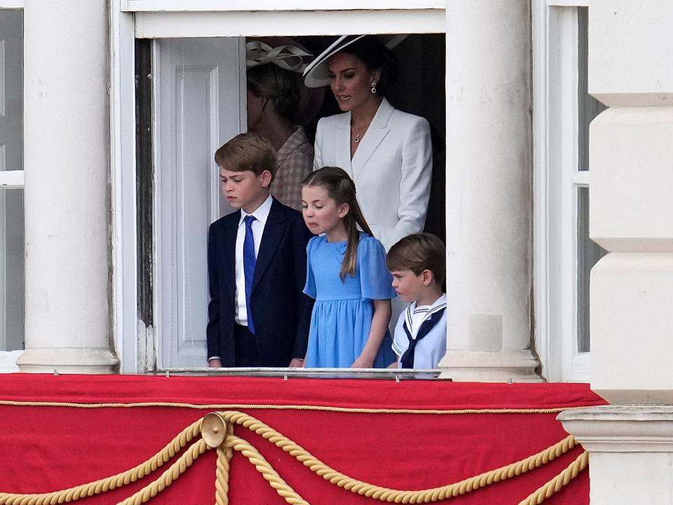 George, Charlotte, Louis, and Kate on the balcony.