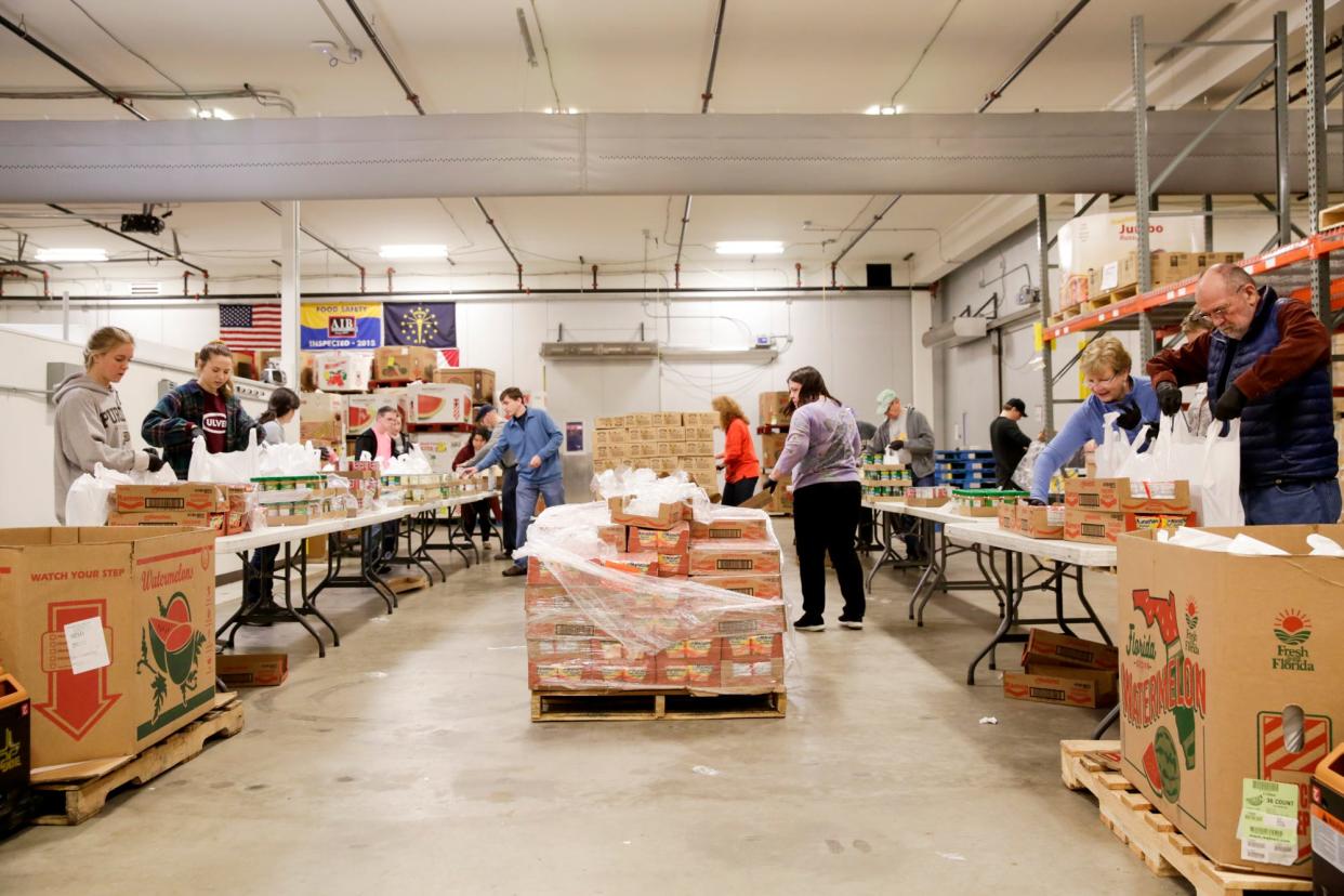 Food Finders Food Bank volunteers pack bags with pre-packaged cans and dried foods at the food bank's warehouse, Friday, March 20, 2020 in Lafayette.