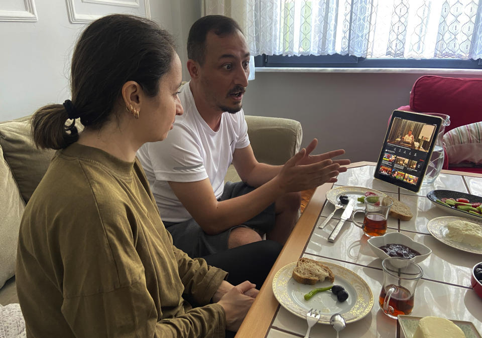 Alparslan Atas, 41, center, gestures as he talks to his wife Gulistan, 38, left, over breakfast at their home in Istanbul, while watching on a tablet, Sedat Peker, a Turkish fugitive crime boss on video, Sunday, June 6, 2021. Sunday is the day the 49-year-old convicted crime ringleader posts the latest installation of his hour-long tell-all videos from his stated base in Dubai that have captivated Turkey and turned the mobster into an unlikely social media phenomenon. The convicted crime ringleader has been dishing the dirt on members of Turkish President Recep Tayyip Erdogan’s ruling party. The allegations range from drug trafficking and a murder cover-up to weapons transfers to Islamic militants. (AP Photo/Mehmet Guzel)