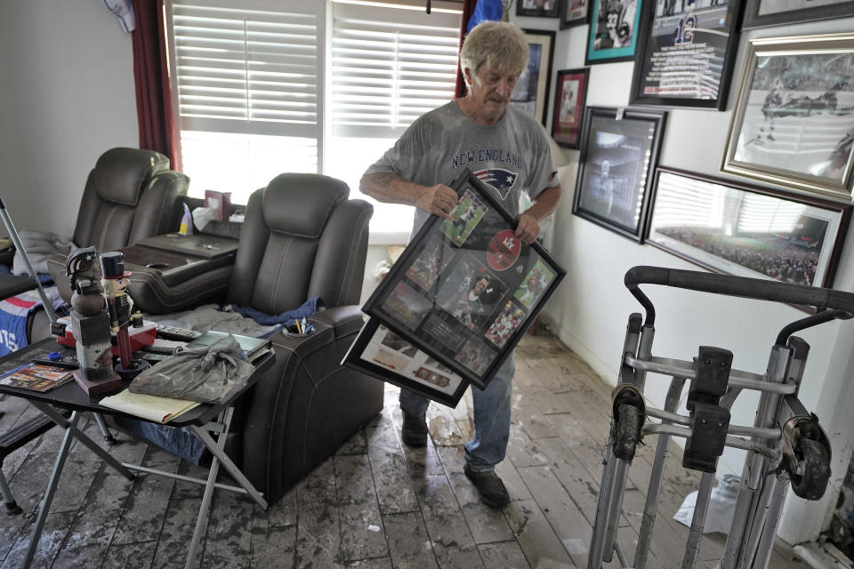 Ron Audette removes water soaked memorabilia from his storm-damaged home after Hurricane Ian, Tuesday, Oct. 4, 2022, in North Port, Fla. (AP Photo/Chris O'Meara)