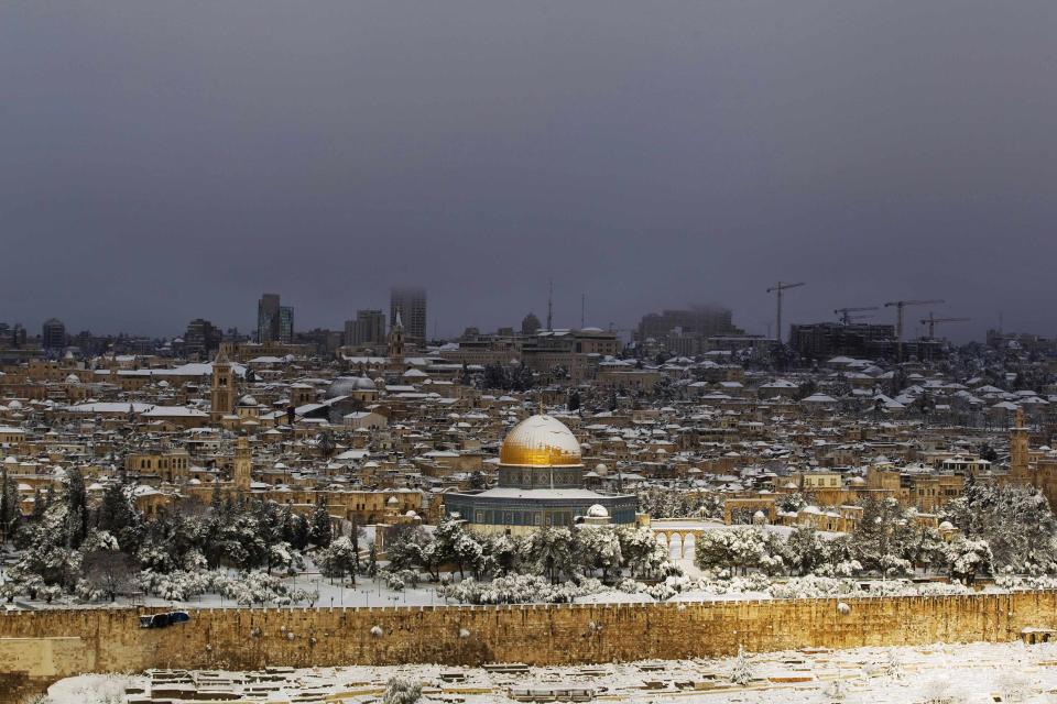 Snow covers the Dome of the Rock in Jerusalem's Old City, as seen from the Mount of Olives