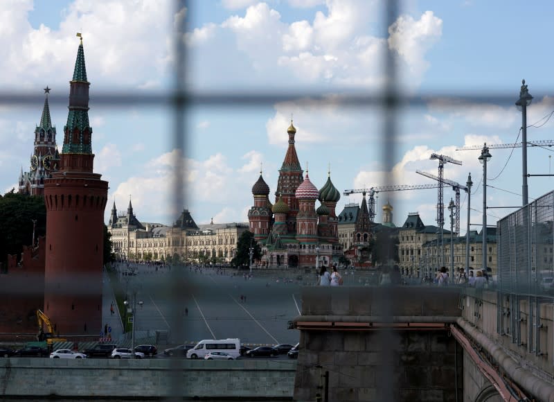 A view through a construction fence shows the Kremlin towers and St. Basil's Cathedral on a hot summer day in central Moscow, Russia, July 1, 2016.  REUTERS/Maxim Zmeyev/File Photo 