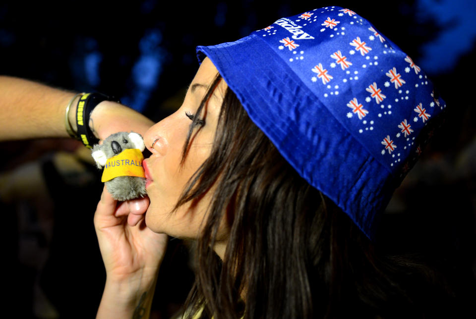 A woman kisses a koala as over 1000 Australian fans spell out the word G'Day on Clapham Common in London, Wednesday, July 25, 2012. The fans attempted to break the Guinness World record for The Most People Wearing The Same Full Team Kit.