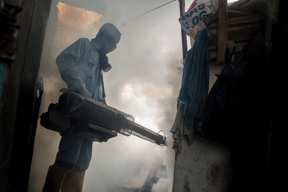 A health worker fogging densely populated areas in Indonesia, on Nov. 7. The fumigation is done to prevent the spread of the Aedes aegypti mosquito, which causes dengue during the rainy season. (Photo: Fachrul Reza/NurPhoto/Getty Images)