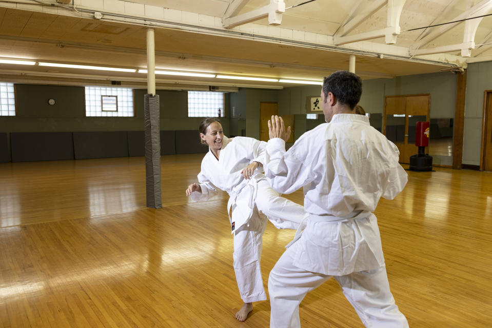 Emily Sohn lanza una patada de práctica a su marido, Gabriel Keller, durante su lección de karate en Kitsune Karate en Minneapolis, Minnesota, el martes 13 de julio de 2021. El karate hará su debut olímpico en los Juegos Olímpicos de Tokio 2020, los cuales fueron pospuestos. (Jenn Ackerman/The New York Times).