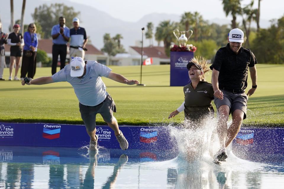 Jennifer Kupcho, center, jumps in the water with her husband Jay Monahan, right, and caddie David Eller after Kupcho's win in the LPGA Chevron Championship golf tournament Sunday, April 3, 2022, in Rancho Mirage, Calif. (AP Photo/Marcio Jose Sanchez)