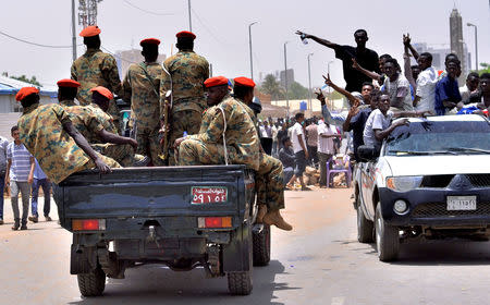 Sudanese demonstrators cheer as they drive towards a military vehicle, after Sudan's Defense Minister Awad Mohamed Ahmed Ibn Auf said that President Omar al-Bashir had been detained "in a safe place" and that a military council would run the country for a two-year transitional period, near Defence Ministry in Khartoum, Sudan April 11, 2019. REUTERS/Stringer