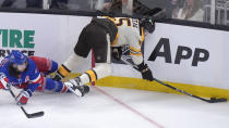 New York Rangers center Mika Zibanejad (93) and Boston Bruins right wing Justin Brazeau (55) slam into the boards as they pursue the puck in the first period of an NHL hockey game, Thursday, March 21, 2024, in Boston. (AP Photo/Steven Senne)