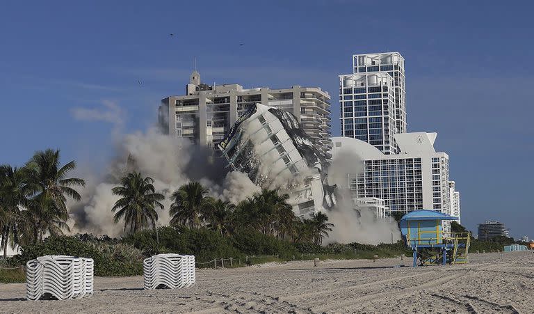 El domingo 13 de noviembre de 2022 la torre del hotel de 17 pisos del histórico Deauville Beach Resort implosiona arrojando una gran cantidad de polvo y escombros a los edificios de lujo situados junto al océano. (Carl Juste/Miami Herald vía AP)