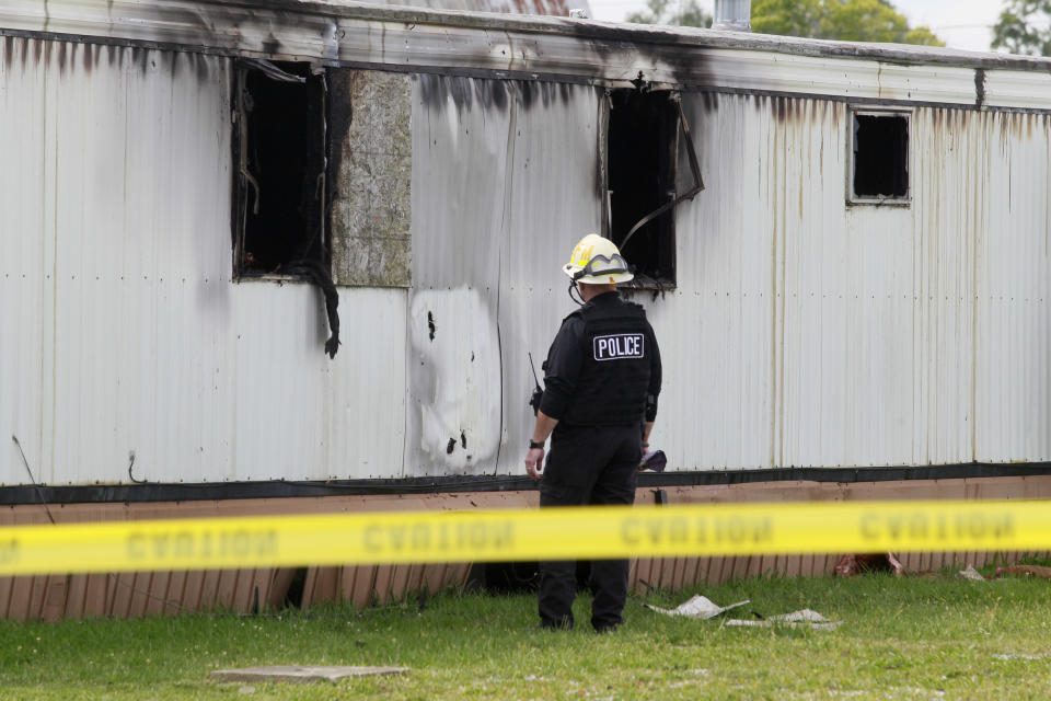 Wm. Timothy Spradlin, with the Division of the State Fire Marshal, investigates into the scene of a fire that killed five children and one adult on Sunday, Sept. 15, 2013, in Tiffin, Ohio. The fire was reported shortly before 8 a.m. Sunday in a mobile home park in Tiffin, about 50 miles southeast of Toledo, Ohio. (AP Photo/The Blade, Amy Voigt)