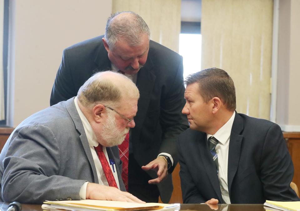 Defense attorneys Mike Callahan and John Greven confer with their client former state Rep. Bob Young before the start of his bench trial in Barberton Municipal Court on Tuesday for assault and domestic violence charges.
