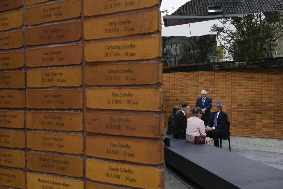 Name stones are seen in the foreground as King Willem-Alexander, right, talks to survivors and relatives after officially unveiling a new monument in the heart of Amsterdam's historic Jewish Quarter on Sunday, Sept. 19, 2021, honoring the 102,000 Dutch victims of the Holocaust. Designed by Polish-Jewish architect Daniel Libeskind, the memorial is made up of walls shaped to form four Hebrew letters spelling out a word that translates as "In Memory Of." The walls are built using bricks each of which is inscribed with the name of one of the 102,000 Jews, Roma and Sinti who were murdered in Nazi concentration camps during World War II or who died on their way to the camps. (AP Photo/Peter Dejong)