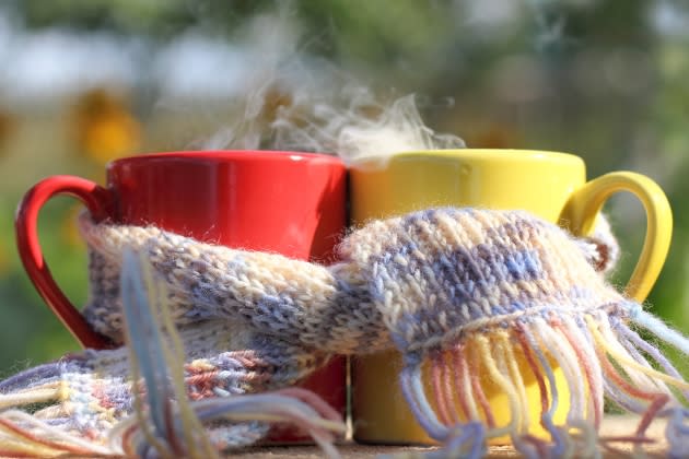 red and yellow mugs wrapped in a scarf on a garden background in - Credit: zoomingfoto1712/Adobe Stock