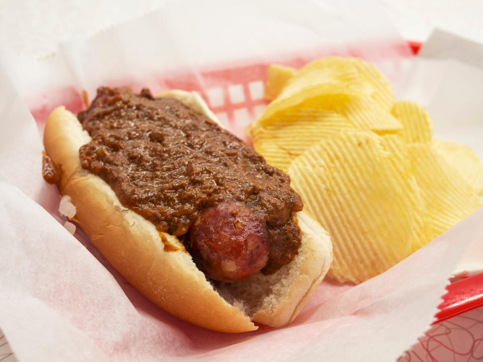 chili half-smoke hot dog in a tray with potato chips