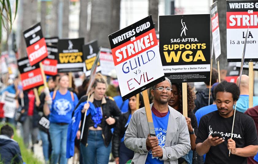 Writers on strike march with signs on the picket line on day four of the strike by the Writers Guild of America in front of Netflix in Hollywood, California on May 5, 2023. - More than 11,000 Hollywood television and movie writers are on their first strike since 2007 after talks with studios and streamers over pay and working conditions failed to clinch a deal. (Photo by Frederic J. BROWN / AFP) (Photo by FREDERIC J. BROWN/AFP via Getty Images)