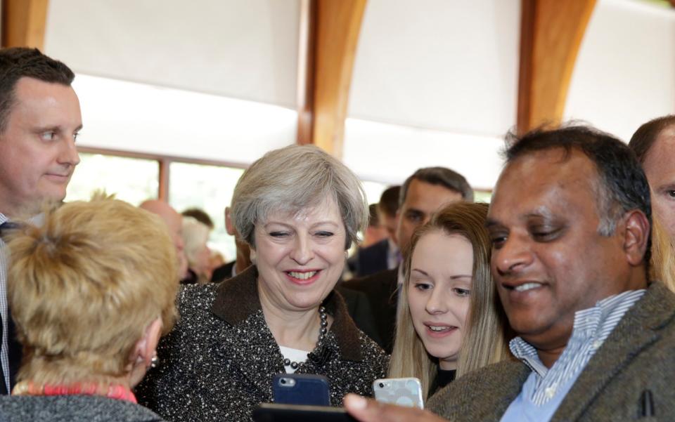 Theresa May smiles for a selfie - Credit: Heathcliff O'Malley