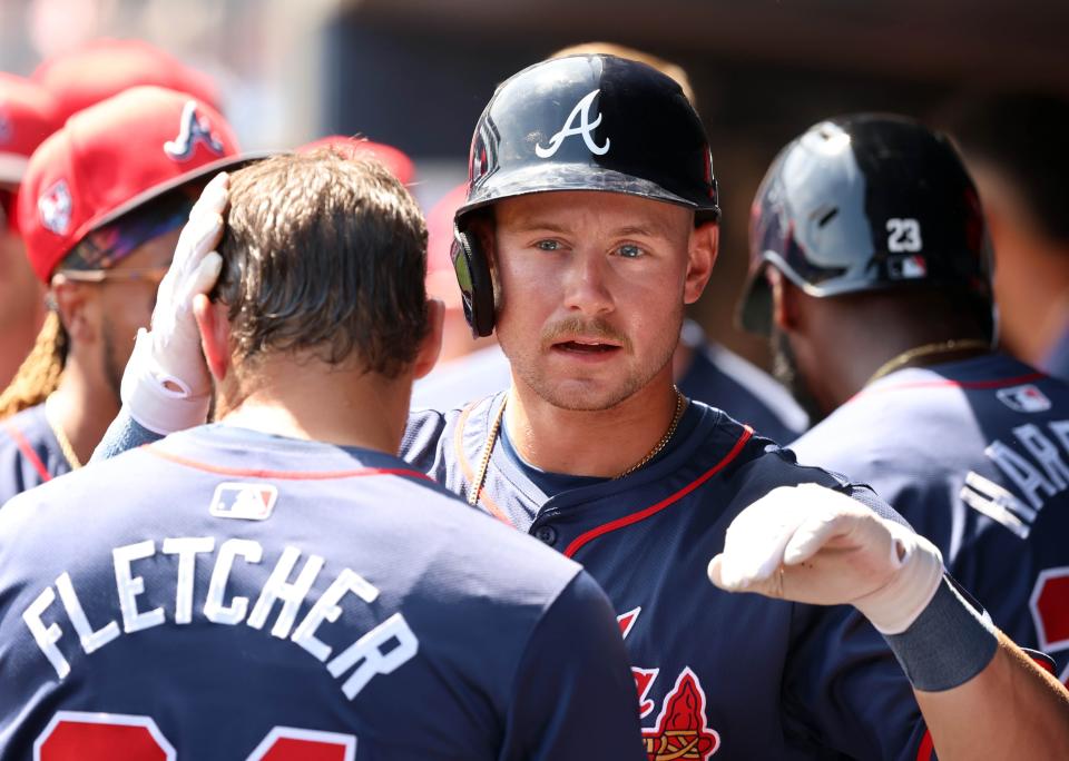 Atlanta Braves left fielder Jarred Kelenic (24) is congratulated after he and infielder David Fletcher (64) scored runs during the first inning against the New York Yankees at George M. Steinbrenner Field during spring training.