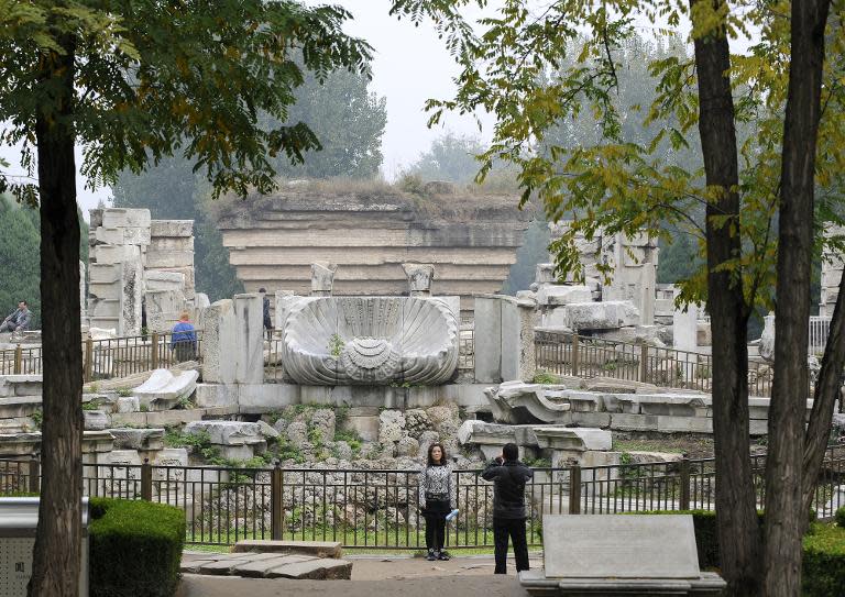 Tourists take pictures in front of the ruins of Haiyan Hall at the Old Summer Palace in Beijing