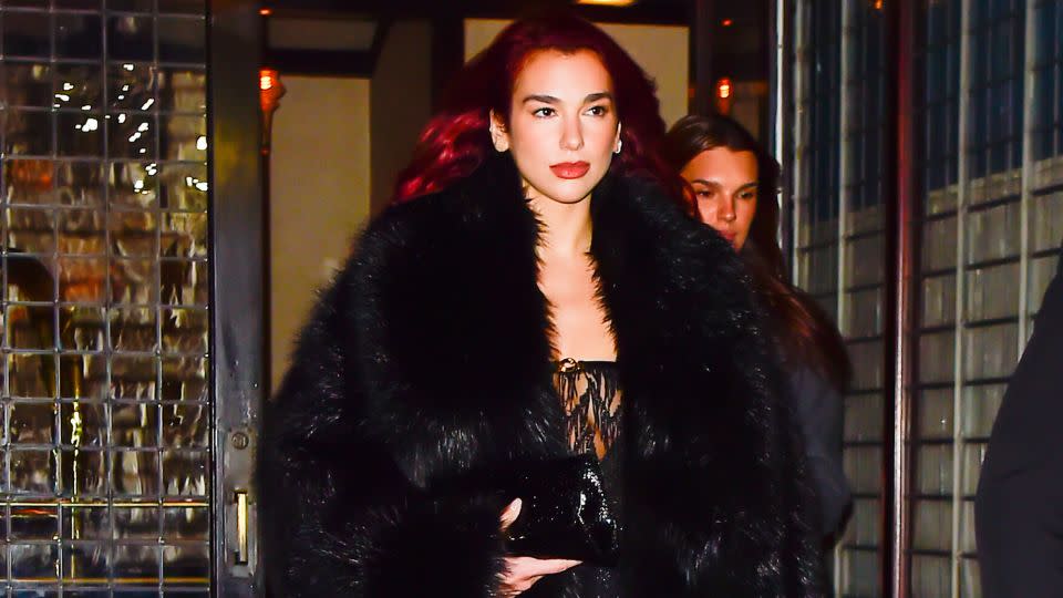 Dua Lipa, seen here in a full-length faux fur coat in New York in November 2023, is a modern adopter of the look. - Raymond Hall/GC Images/Getty Images