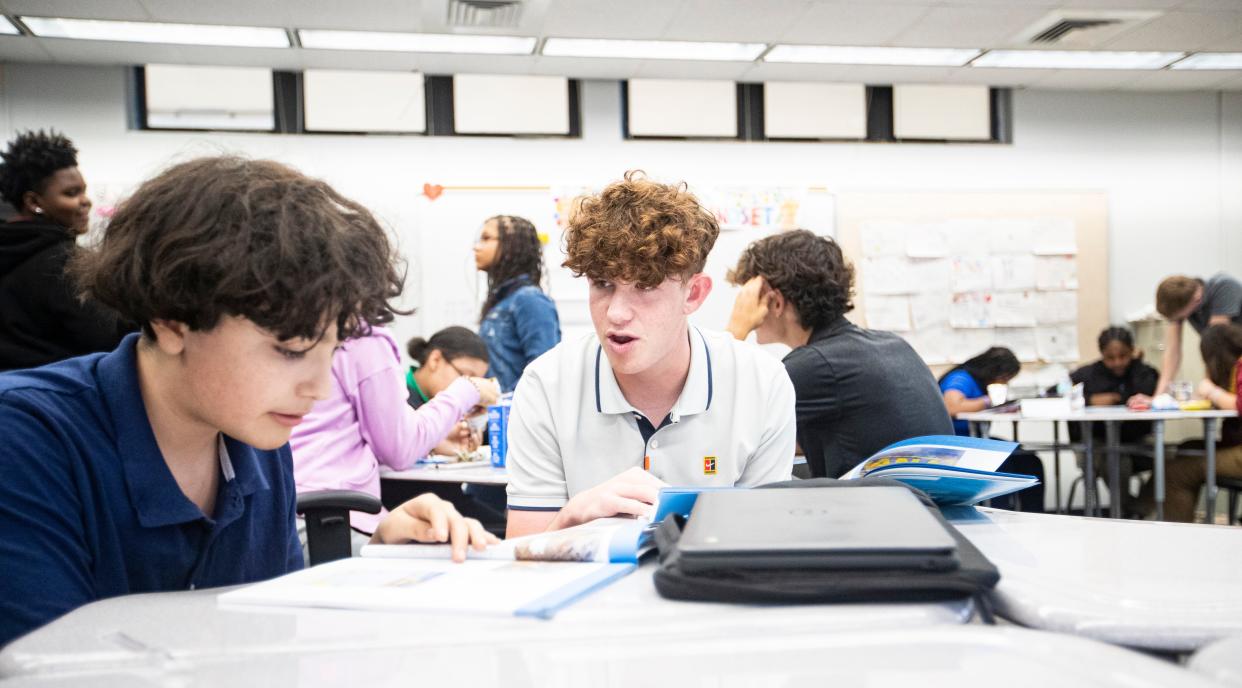 Dylan Moon, president and chairman of Creating Role Models and Mentors, works with Fort Myers Middle Academy student David Perez during an after-school session at the school in March. He founded the program during his eighth-grade year in the middle of the COVID-19 pandemic. He wanted to help students struggling with virtual learning.  The group raised thousands through a pickleball tournament and were able to offer scholarships. One of the recipients is David.