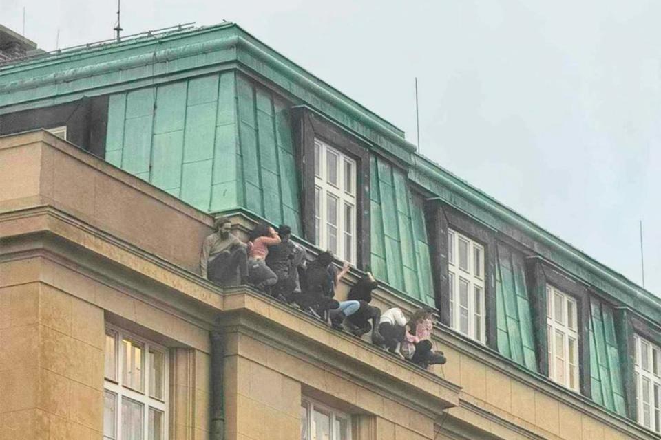 Eight students seen hiding on a building ledge to escape the gunman (Supplied)