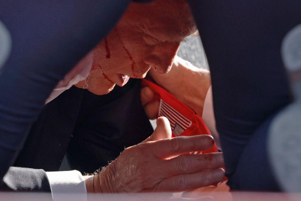 Secret Service tending to Donald Trump onstage at a rally in Butler, Pennsylvania, after he was shot at.