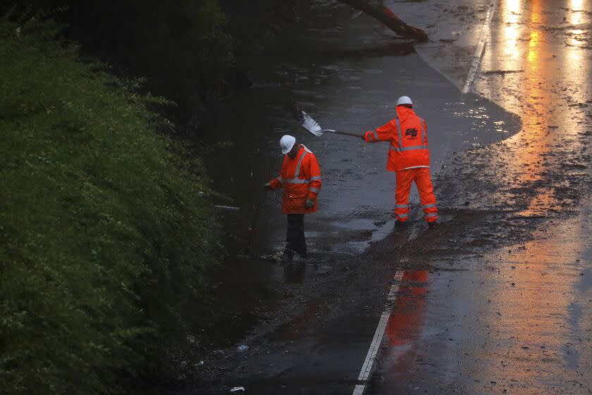 A Caltrans crew works to clear a flooded portion of northbound Highway 13 on Tuesday, Dec. 27, 2022, in Oakland, Calif. Rain is expected across the Bay Area this week. (Aric Crabb/Bay Area News Group via AP)