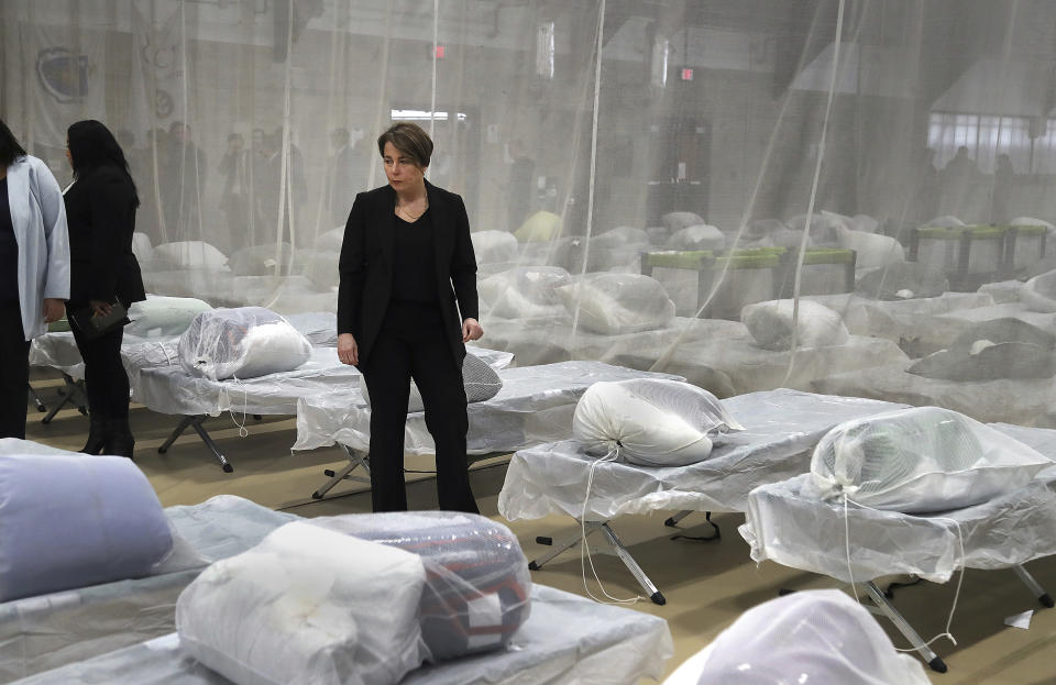 Massachusetts Governor Maura Healey pauses to look at the Army cots set up on the gym floor as State and local officials toured the Melnea A. Cass Recreational Complex Wednesday, Jan. 31, 2024, in the Roxbury neighborhood of Boston. The facility will house over 300 migrants. (John Tlumacki/The Boston Globe via AP, Pool)