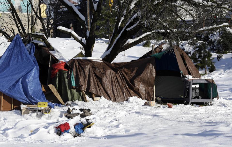 In this Friday, Jan. 13, 2017 photo, a homeless camp is seen in a snowy field under a tree in Portland, Ore.,. A stillborn infant was found with his homeless mother at a Portland bus stop in the cold earlier this month and, while the infant's death was not blamed on the cold, it has drawn more attention to an unusually harsh winter that has led to several exposure deaths among the city's homeless. (AP Photo/Don Ryan)