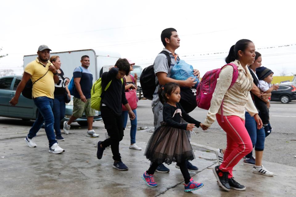 Migrants walk along a highway as a new caravan of several hundred people sets off in hopes of reaching the distant United States, in San Pedro Sula, Honduras, shortly after dawn Wednesday, April 10, 2019. Parents who gathered at the bus station with their children to join the caravan say they can't support their families with what they can earn in Honduras and are seeking better opportunities.