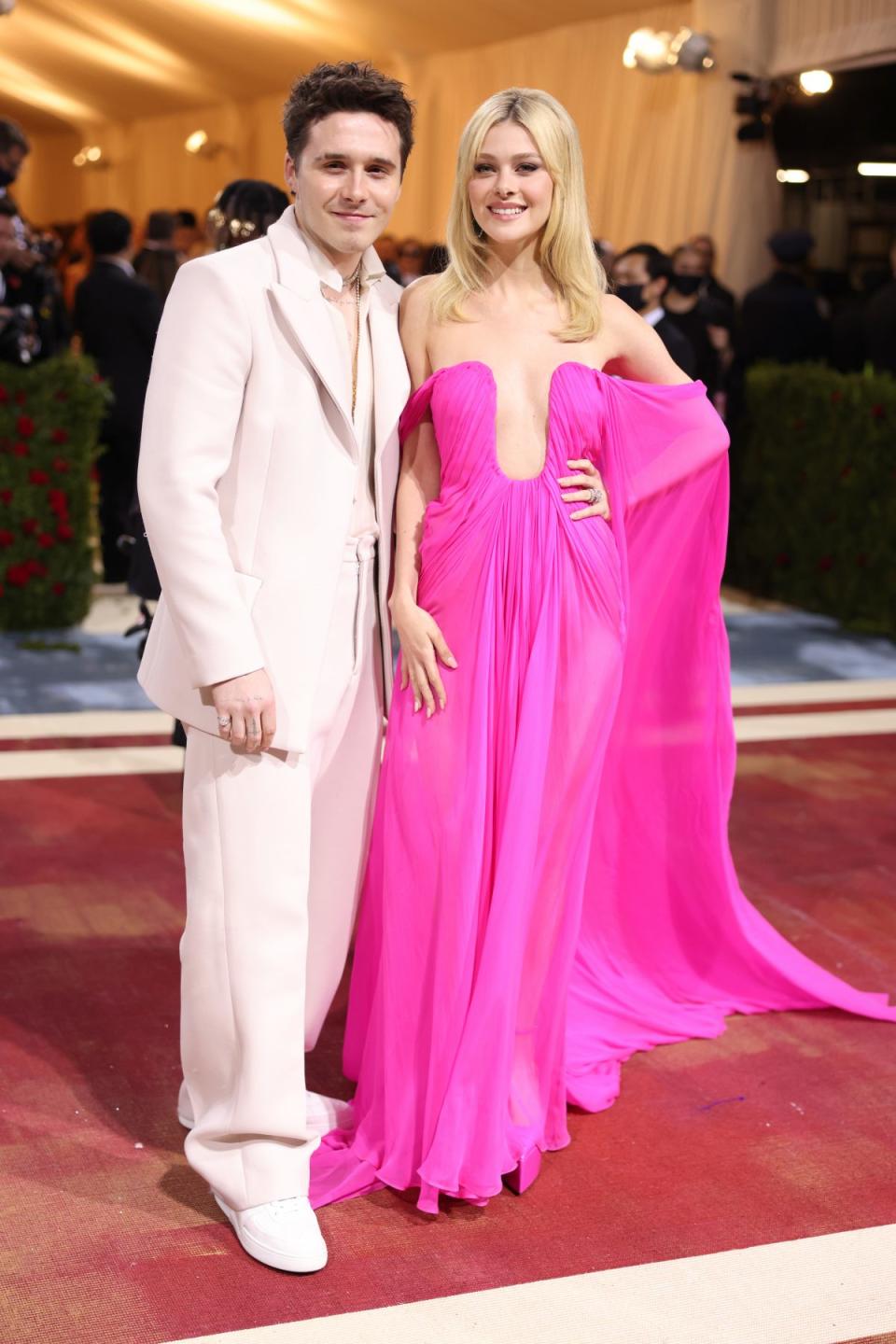 2022 Met Gala，剛剛完婚的 Nicola & Brooklyn Peltz Beckham 分別穿上 Valentino FW23 粉色禮服以及 SS22 高級訂製西裝造型。