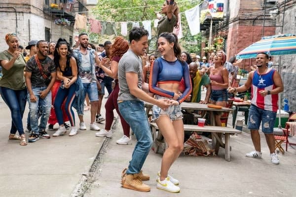 Anthony Ramos and Melissa Barrera dancing in an alley surrounded by a crowd