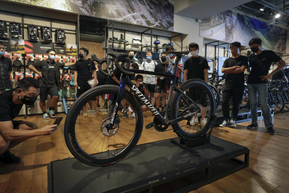 Customers wearing face masks to help curb the spread of the coronavirus look at a newly unveiled new model from the American bicycle brand at a retailed shop in Beijing on July 29, 2020. China's trade growth accelerated in September as the world's second-largest economy recovered form the coronavirus pandemic. (AP Photo/Andy Wong)