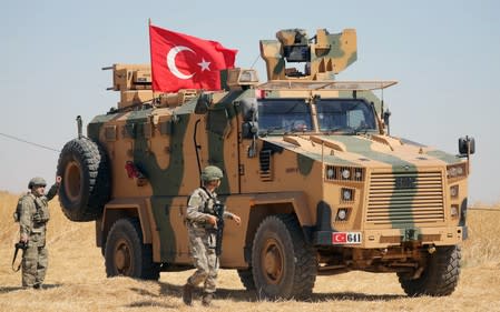 FILE PHOTO: A Turkish soldier walks next to a Turkish military vehicle during a joint U.S.-Turkey patrol, near Tel Abyad