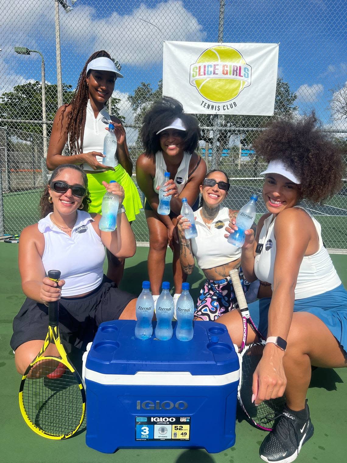 Slice Girls Tennis Club co-founders Carole Hollant (left), Alexandra Philius (second from left), Shaina Jean Louis (middle) and Francesca Morgan (right) pose with participant Starr Hawkins (second from right) during a lesson. Founded by four Miami natives in 2022, the club creates a space for women of color to be themselves while learning a skill historically reserved for the white elite. Slice Girls Tennis Club