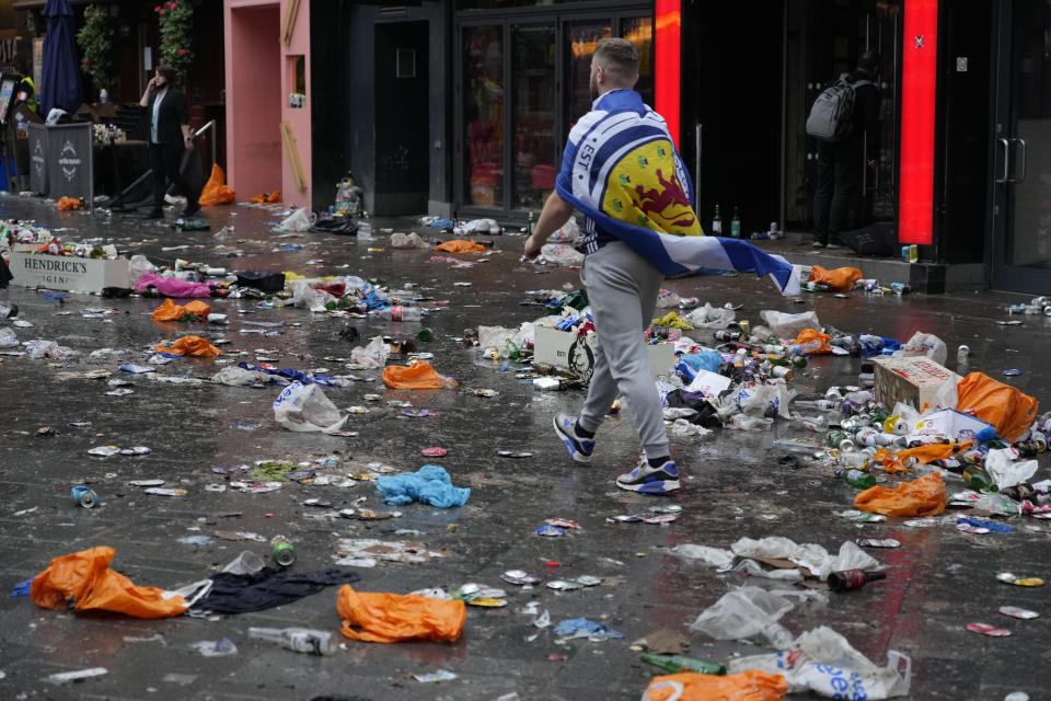 A Scotland fan walks amidst rubbish left behind by partying fans prior to the Euro 2020 soccer championship group D match between England and Scotland, in London, Friday, June 18, 2021. (AP Photo/Kirsty Wigglesworth)