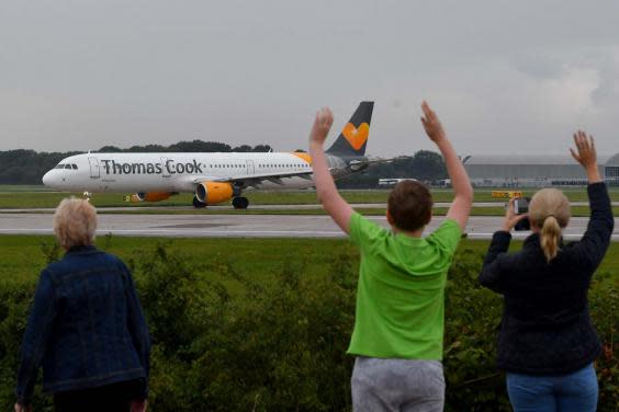 A pilot's family wave as a Thomas Cook plane departs from Manchester with the travel giant's future still uncertain (Getty)