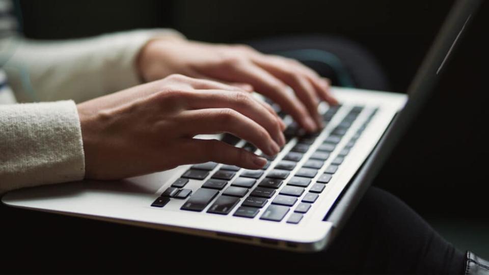 hands typing on laptop