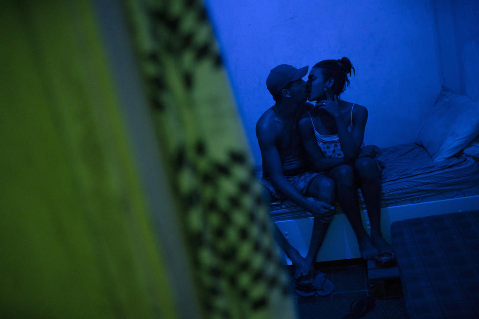 Richard Santos and his partner Lia kiss in their bedroom in the squat known as Casa Nem, occupied by members of the LGBTQ community who are in self-quarantine as a protective measure against the new coronavirus, in Rio de Janeiro, Brazil, Saturday, May 23, 2020. Several years ago Casa Nem became a shelter for LGBTQ victims of violence and those who, rejected by their families, have nowhere to live. (AP Photo/Silvia Izquierdo)