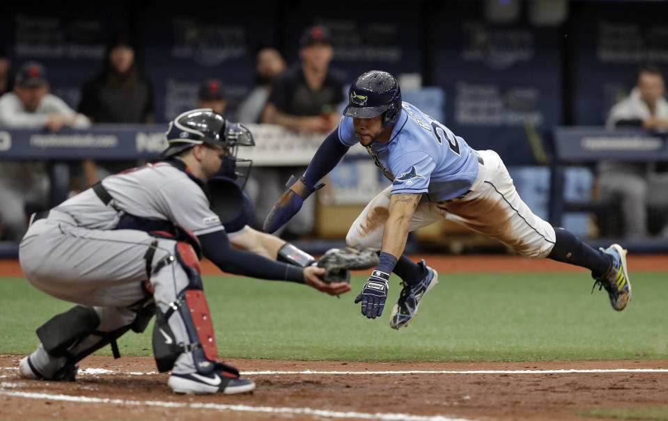 Tampa Bay Rays' Tommy Pham, right, prepares to get tagged out by Cleveland Indians catcher Kevin Plawecki while trying to score on a double by Travis d'Arnaud during the fifth inning of a baseball game Sunday, Sept. 1, 2019, in St. Petersburg, Fla. (AP Photo/Chris O'Meara)