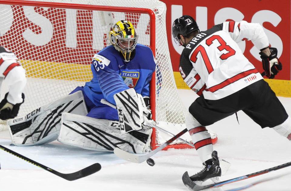 Canada's Brandon Pirri, right, challenges for the puck with Italy's goaltender Davide Fadani during the Ice Hockey World Championship group B match between Italy and Canada at the Arena in Riga, Latvia, Sunday, May 30, 2021. (AP Photo/Sergei Grits)