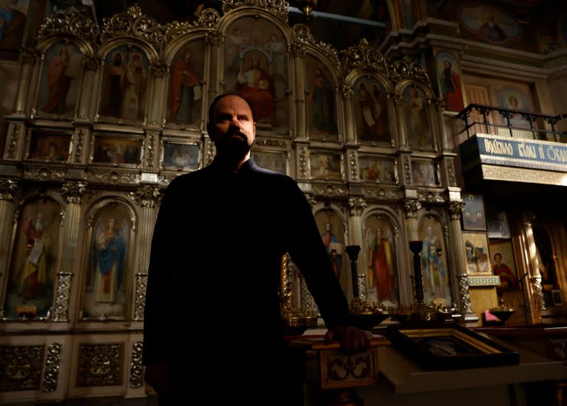 Parish priest Andriy Klyushev poses for a photo, as Russia's attack on Ukraine continues, in Saint Nicholas church, Irpin